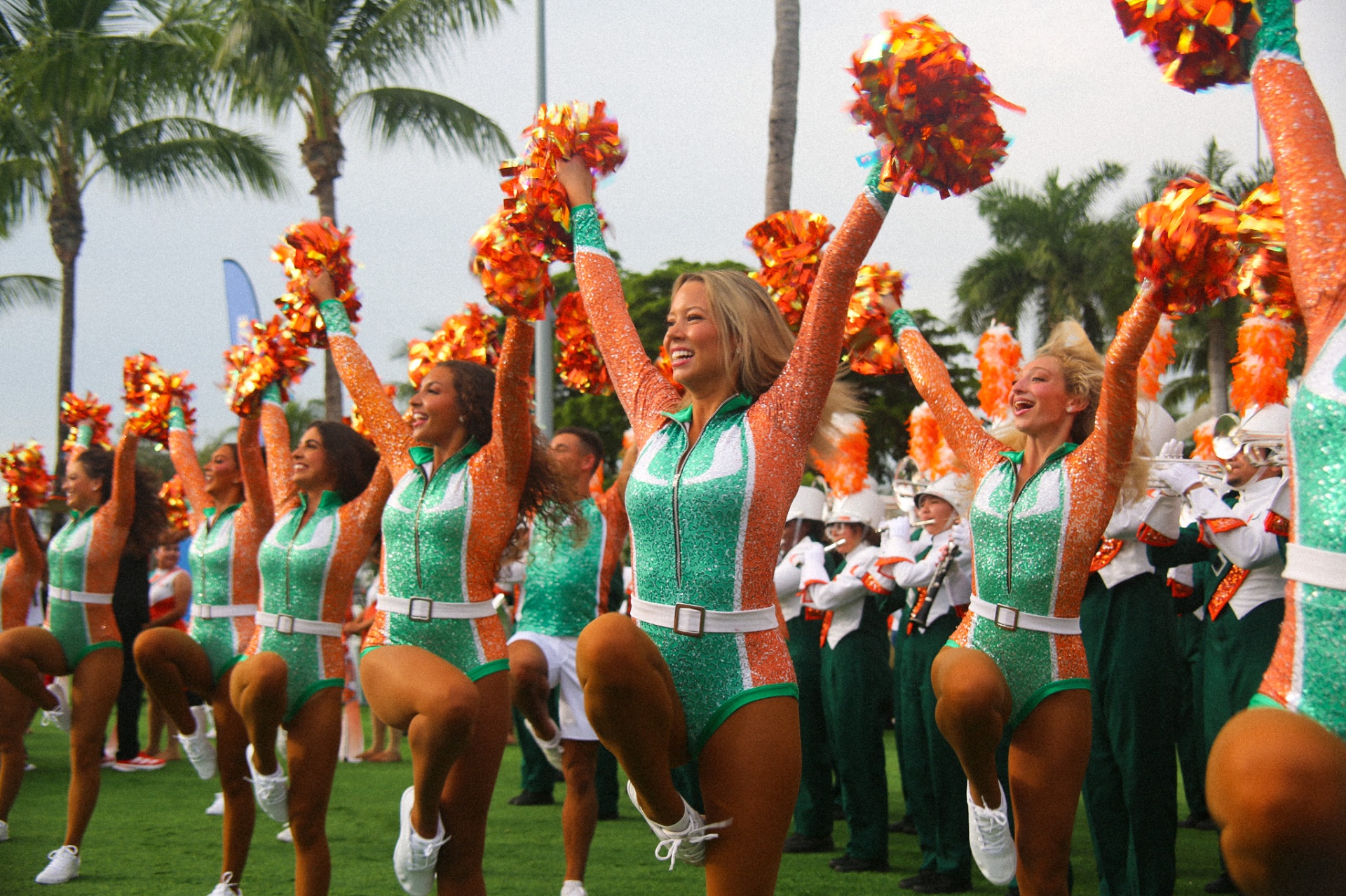 Miami Hurricanettes performing with pom-poms in front of the Band of the Hour